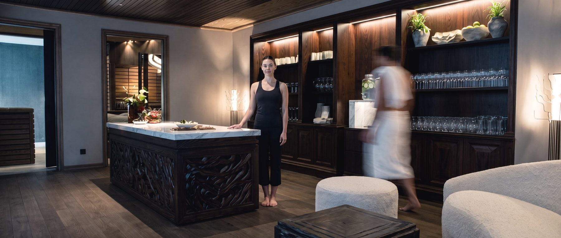 Reception. The guide stands still behind the marble desk while a guest arriving through the room blurs past her.