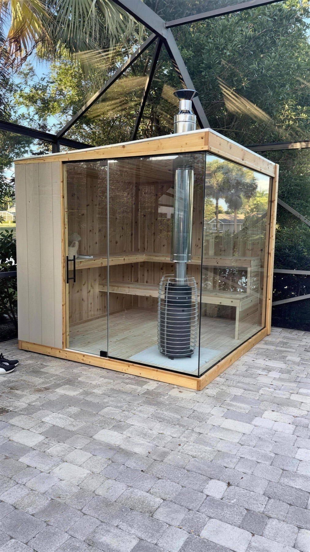 Glass-front sauna with a wood-burning stove on a screened lanai
